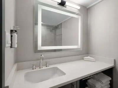 a white bathroom with a sink and a mirror at Holiday Inn Calgary Airport by IHG in Calgary