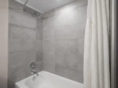 a bathroom with a shower with a tub and a shower curtain at Holiday Inn Calgary Airport by IHG in Calgary