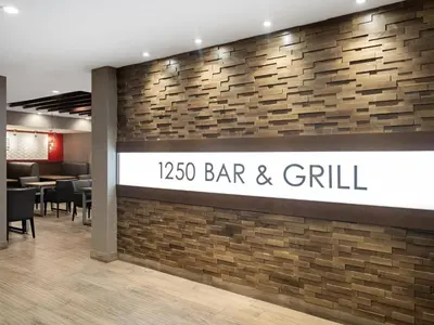 a bar and grill sign on a brick wall at Holiday Inn Calgary Airport by IHG in Calgary