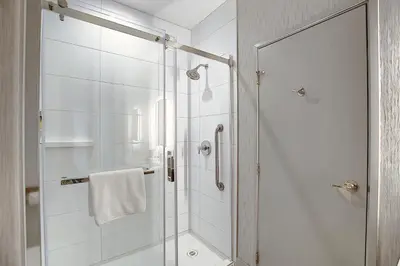 a bathroom with a shower with a glass door at Holiday Inn Express Airport Calgary by IHG in Calgary