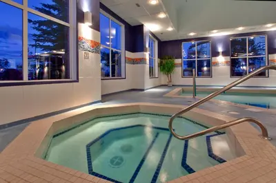 a swimming pool in a hotel room with a hot tub at Holiday Inn Express Calgary South by IHG in Calgary