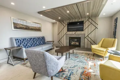 a living room with a couch and a fireplace at Holiday Inn Express Calgary South by IHG in Calgary