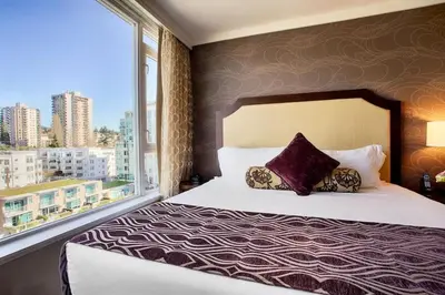 a bedroom with a bed and a large window at Pinnacle Hotel at the Pier in North Vancouver