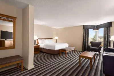 a hotel room with a bed and a living room at Royal Hotel West Edmonton, Trademark Collection by Wyndham in Edmonton