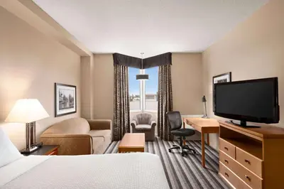 a hotel room with a bed and a flat screen tv at Royal Hotel West Edmonton, Trademark Collection by Wyndham in Edmonton