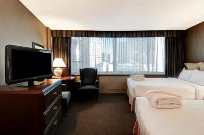 a hotel room with two beds and a flat screen tv at Chateau Lacombe Hotel in Edmonton