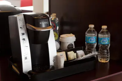 a coffee maker and bottles of water on a counter at Chateau Lacombe Hotel in Edmonton
