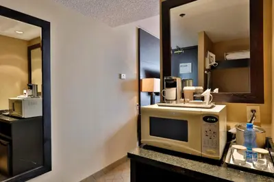 a hotel room with a microwave and a mirror at Edmonton Hotel & Convention Center Edmonton in Edmonton