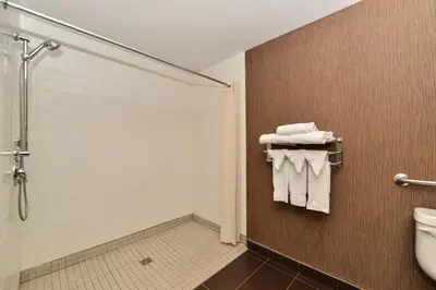 a bathroom with a shower and a toilet and towels at Edmonton Hotel & Convention Center Edmonton in Edmonton