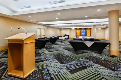 a conference room with a podium and tables and chairs at Holiday Inn Express & Suites Langley by IHG in Langley