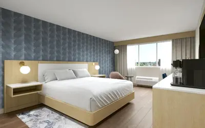 a bedroom with a bed and a tv in a room at Hotel Kelowna & Conference Centre in Kelowna