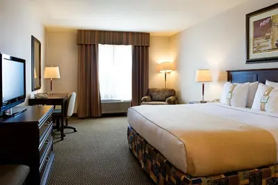 a hotel room with a bed and a desk and a television at Holiday Inn Hotel & Suites-West Edmonton by IHG in Edmonton