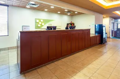 a woman standing at a counter in a lobby at Holiday Inn Hinton by IHG in Hinton