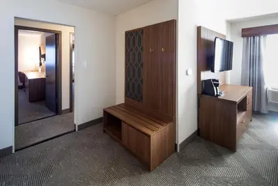 a hotel room with a television and a wooden cabinet at Holiday Inn Hinton by IHG in Hinton