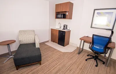 a room with a chair and a desk at Holiday Inn Express Hotel & Suites-Hinton by IHG in Hinton