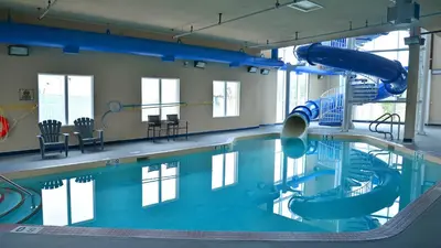 an indoor swimming pool with a water slide at Holiday Inn Express Hotel & Suites-Hinton by IHG in Hinton
