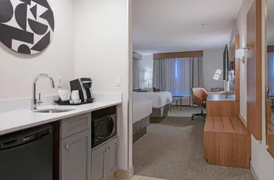 a hotel room with a bed and a kitchen with a sink at Holiday Inn Hotel and Suites-Kamloops by IHG in Kamloops
