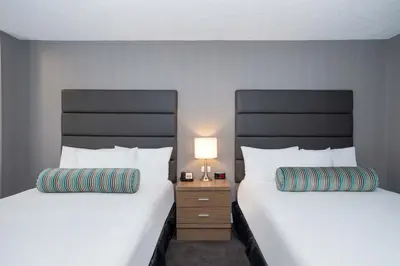two beds sitting next to each other in a room at Sandman Signature Calgary Downtown Hotel in Calgary