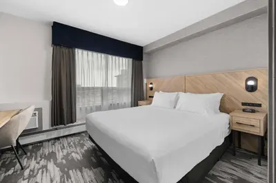 a hotel room with a large bed and a desk at Sandman Hotel Calgary Airport in Calgary