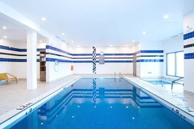 a swimming pool with blue and white stripes on the walls at Sandman Hotel Calgary Airport in Calgary