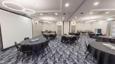 a conference room with tables and chairs and a room with at Sandman Hotel Calgary Airport in Calgary