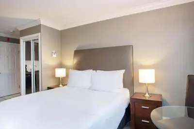 a bedroom with a large white bed with two lamps at Sandman Hotel Vancouver Airport in Richmond