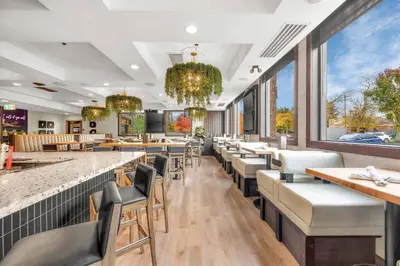 a dining room with tables and chairs and windows at Sandman Hotel Vancouver Airport in Richmond
