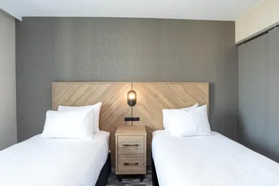 two beds sitting next to each other in a room at Sandman Suites Vancouver on Davie in Vancouver