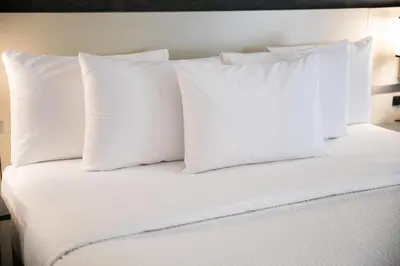 a white bed with white pillows on top of it at Days Inn by Wyndham Vancouver Airport in Richmond