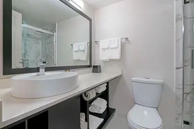 a white bathroom with a sink and a toilet at Best Western Plus Sands in Vancouver