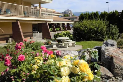 a garden with flowers in front of a building at Dilworth Inn Kelowna in Kelowna
