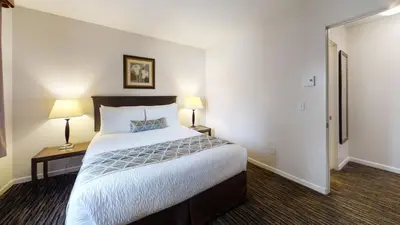 a hotel room with a large bed and two lamps at Recreation Inn and Suites Kelowna in Kelowna