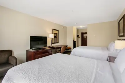 a hotel room with two beds and a flat screen tv at Holiday Inn & Suites Lloydminster by IHG in Lloydminster