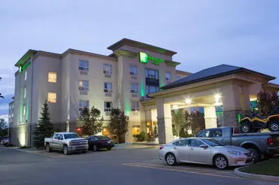 a hotel with cars parked in a parking lot at Holiday Inn & Suites Lloydminster by IHG in Lloydminster