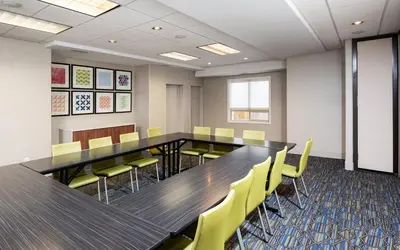a conference room with a long table and yellow chairs at Holiday Inn Express Grande Prairie by IHG in Grande Prairie