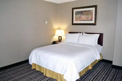 a hotel room with a large white bed with a lamp at Holiday Inn Express Red Deer by IHG in Red Deer