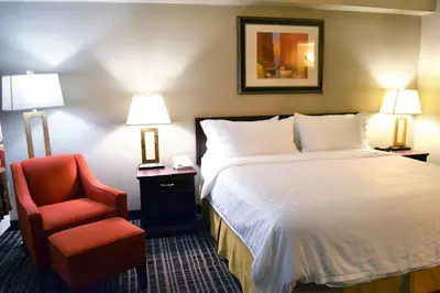 a hotel room with a bed and a red chair at Holiday Inn Express Red Deer by IHG in Red Deer