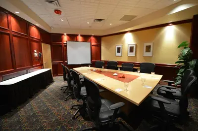 a conference room with a large wooden table and chairs at iHOTEL & Conference Centre Red Deer in Red Deer