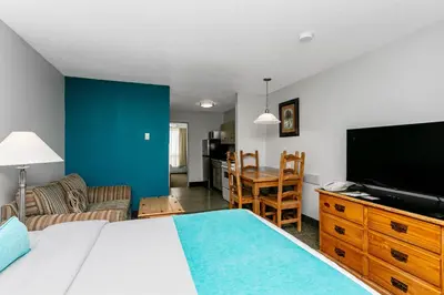 a bedroom with a bed and a flat screen tv at Tonquin Inn in Jasper