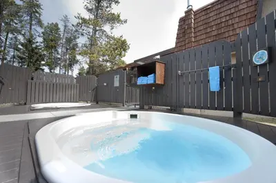 a large bath tub on a patio with a fence at Tonquin Inn in Jasper