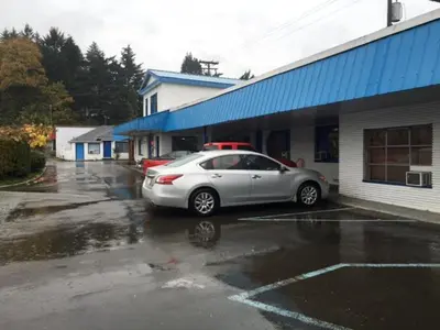 a silver car parked in a parking lot next to a building at Bluebird Motel in Port Alberni