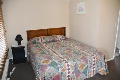 a bedroom with a bed with a colorful comforter at Bluebird Motel in Port Alberni