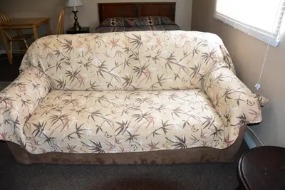 a couch in a living room with a flower pattern at Bluebird Motel in Port Alberni