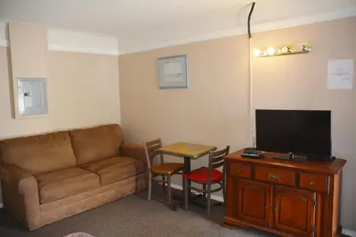 a living room with a couch and a table with a television at Bluebird Motel in Port Alberni