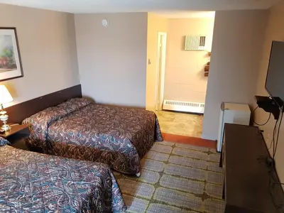 a hotel room with two beds and a television at Alaskan Motel in Fox Creek