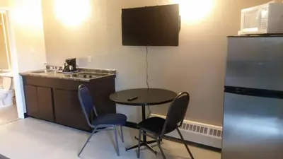 a small kitchen with a table and two chairs at Alaskan Motel in Fox Creek