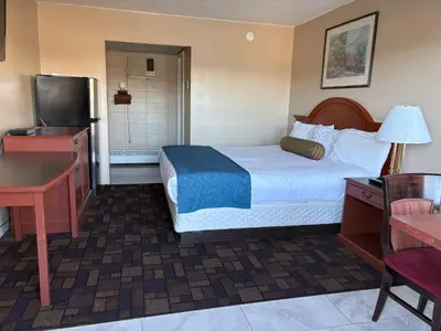 a hotel room with a bed and a television at Alaskan Motel in Fox Creek