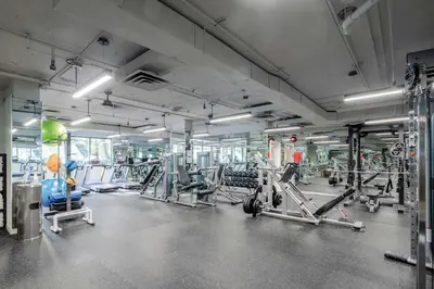 a gym with several treadmills and machines at La Grande Residence at the Sutton Place Hotel in Vancouver