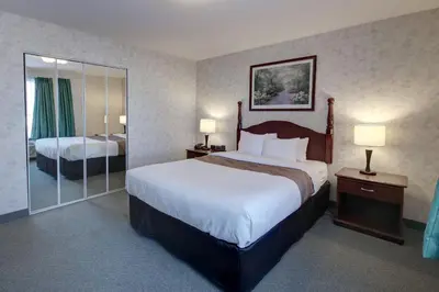 a hotel room with a large bed and a mirror at Ramada by Wyndham Nisku Edmonton Airport in Nisku
