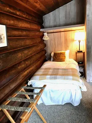 a bedroom with a bed in a log cabin at The Surf Lodge and Pub in Gabriola